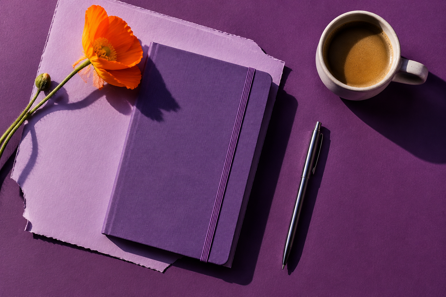 A playful purple creative workspace with a notebook, flower, pen, and coffee